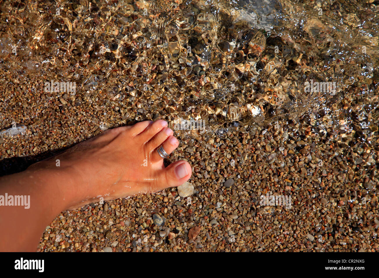 Le donne è sulla sabbiosa spiaggia bagnata Foto Stock