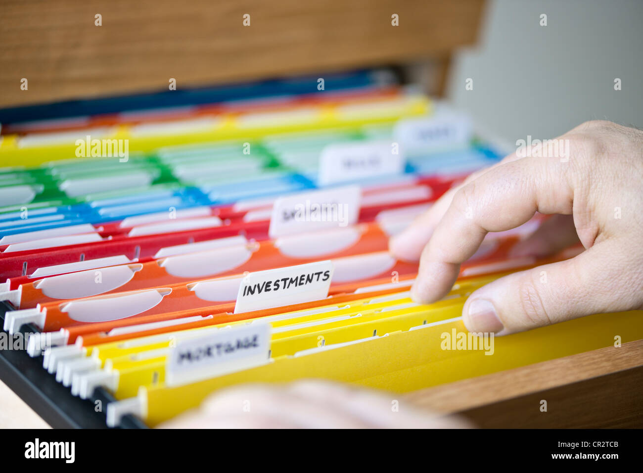 Le mani attraverso la ricerca di cartelle di file personali con documenti finanziari Foto Stock
