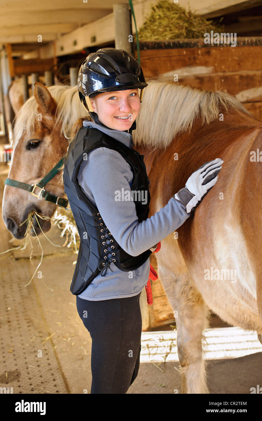 Ritratto di ragazza adolescente a cavallo in stabile Foto Stock