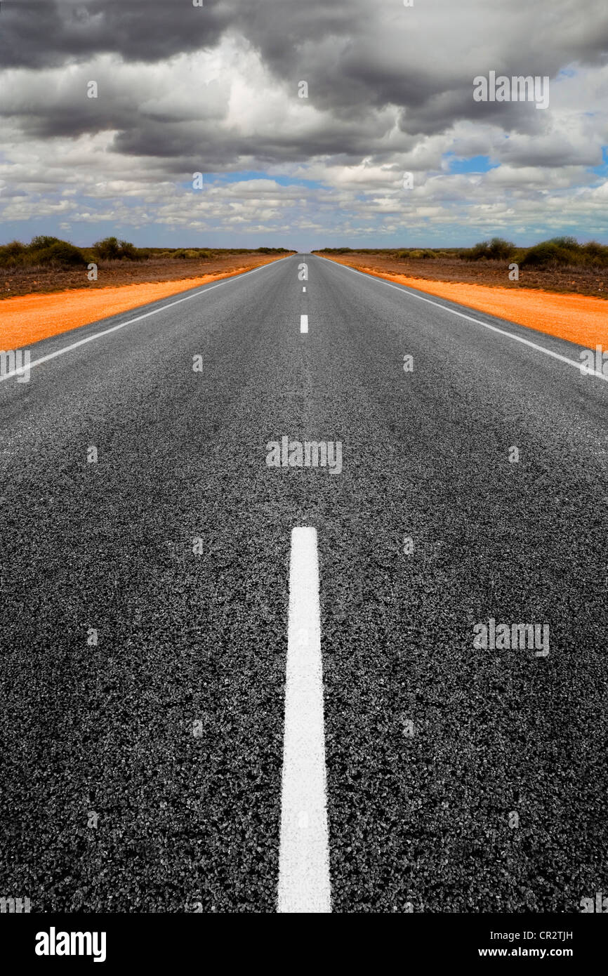Lunga strada diritta in Western Australia con raccolta nubi overhead. Foto Stock
