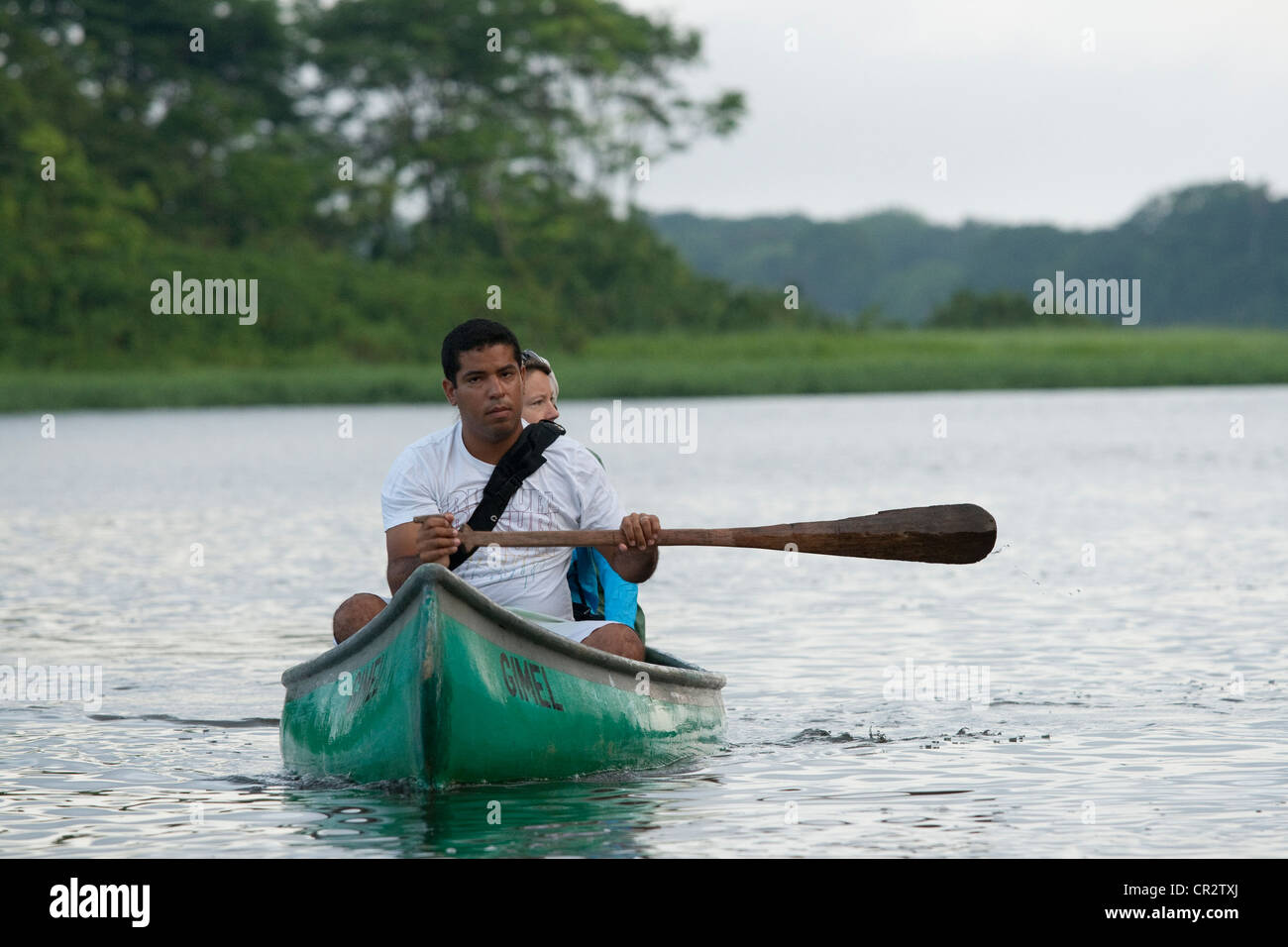 L uomo e la donna in canoa peddling sulle rive di un fiume Foto Stock