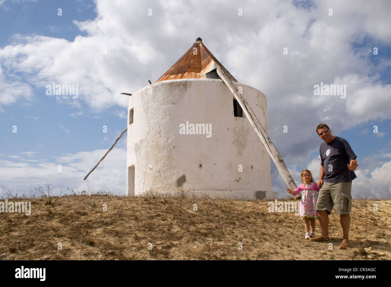 Padre e figlia accanto a uno dei vecchi mulini a vento in Vejer de la Frontera Foto Stock