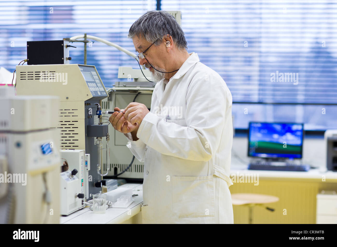 Maschio senior researcher di effettuare attività di ricerca scientifica in un laboratorio (SHALLOW DOF; dai toni di colore immagine) Foto Stock