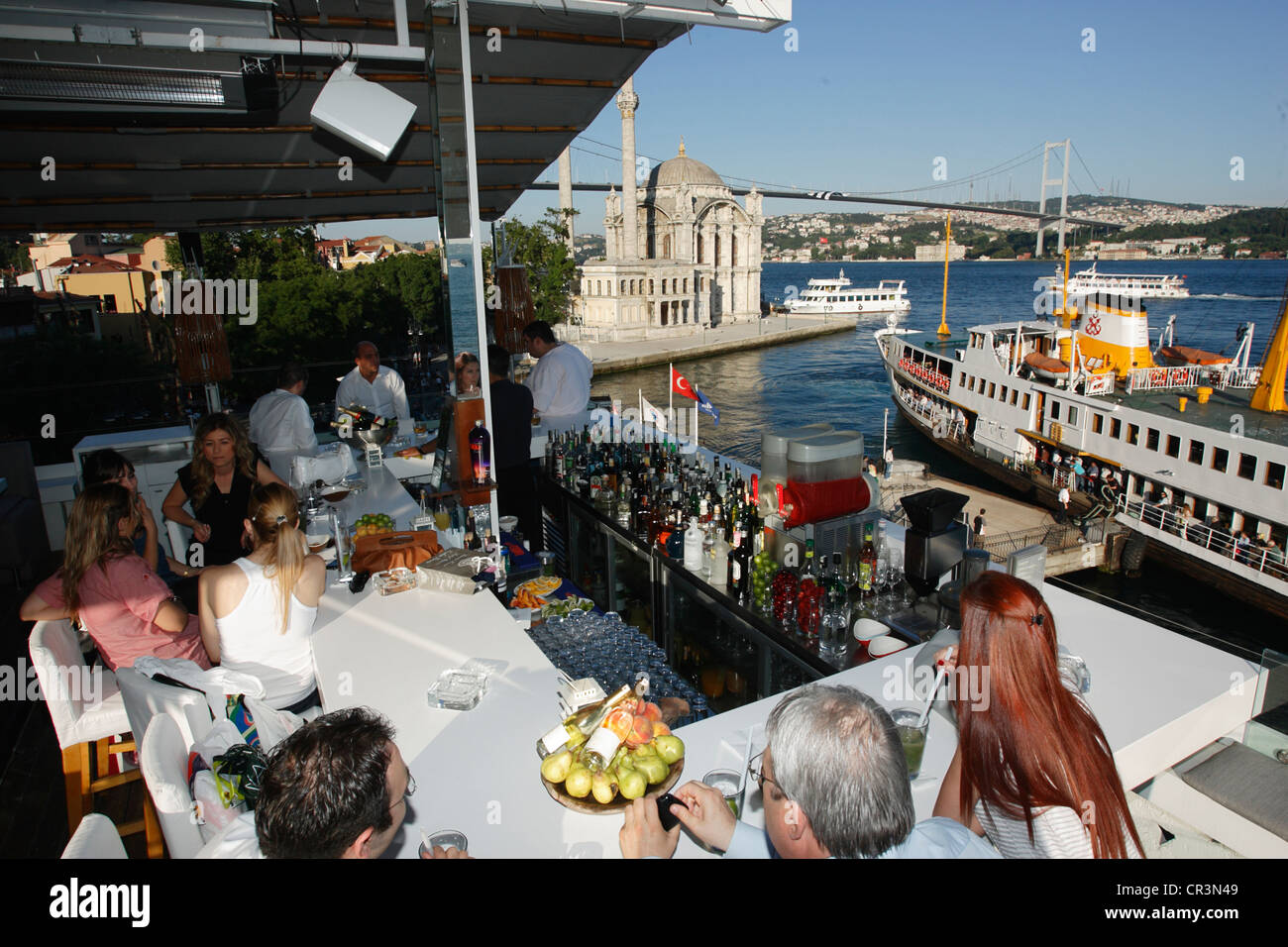 Turchia, Istanbul, bar sulle rive del Bosforo, Moschea Ortakoy e Ponte sul Bosforo in background Foto Stock