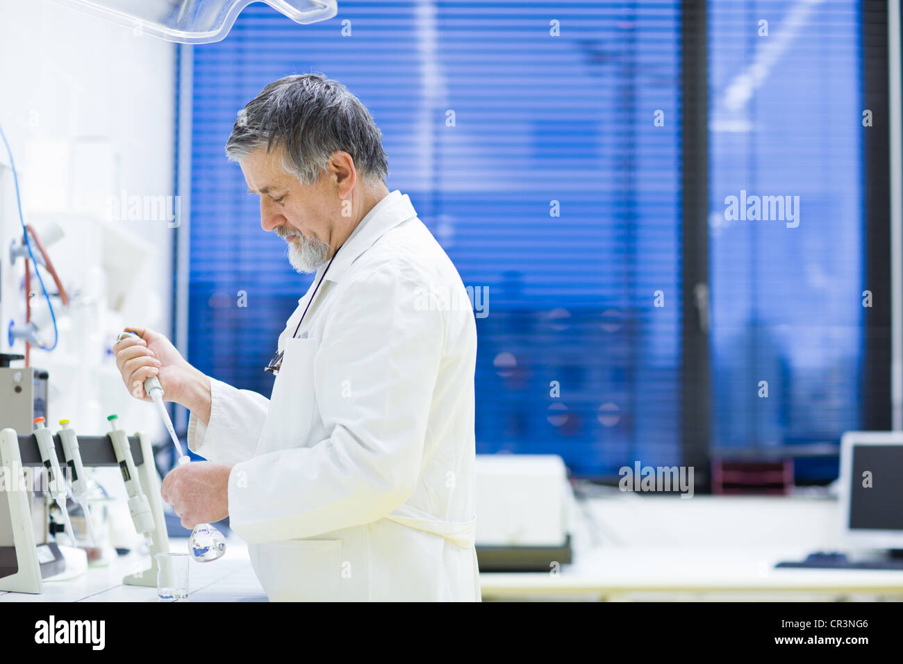 Maschio senior researcher di effettuare attività di ricerca scientifica in un laboratorio (SHALLOW DOF; dai toni di colore immagine) Foto Stock