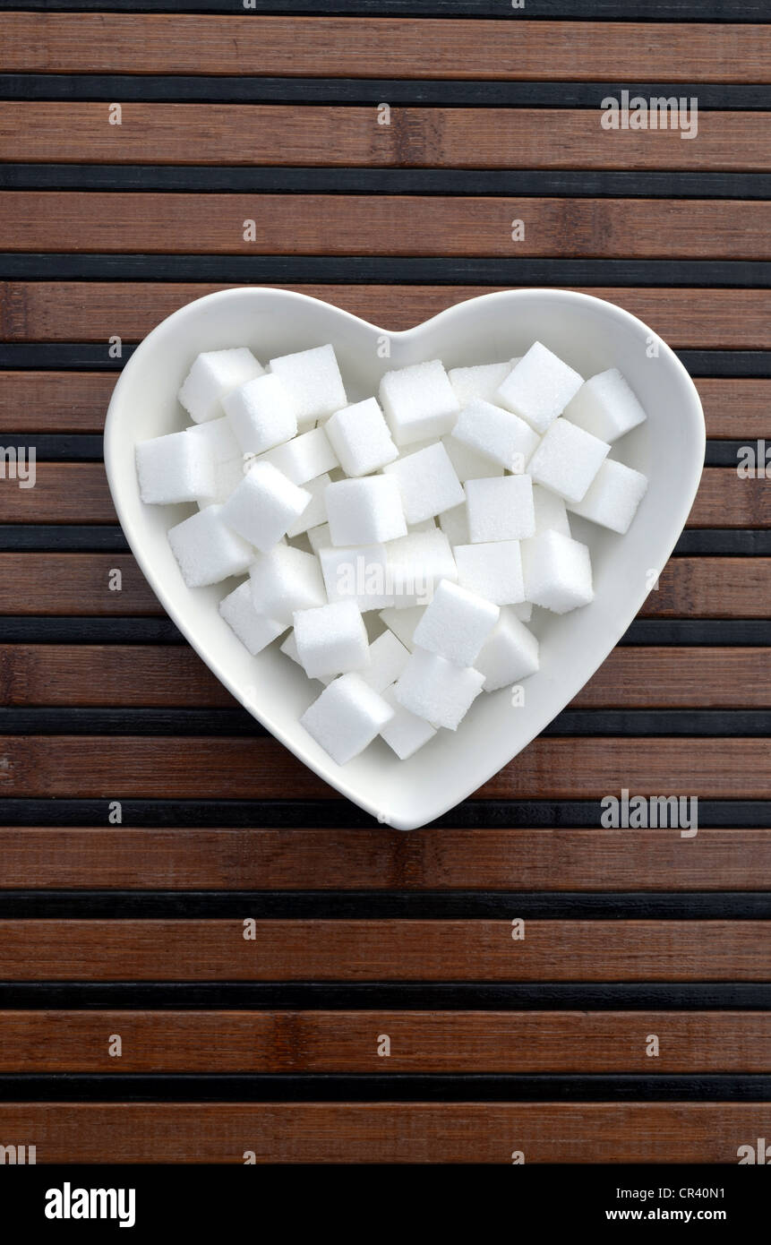Zollette di zucchero in un cuore a forma di tazza di porcellana
