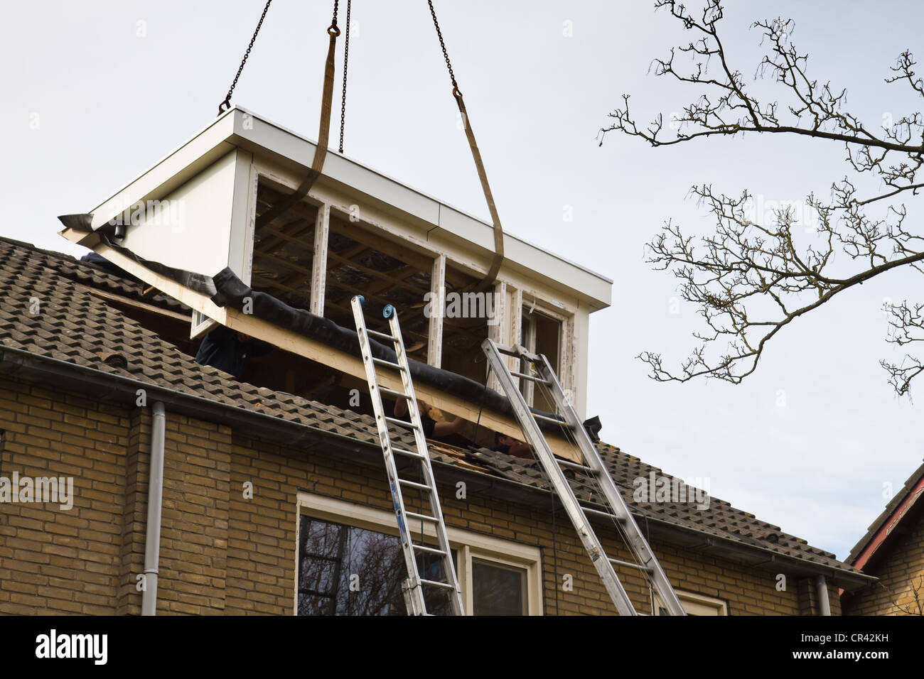 La collocazione di nuovi e più grandi dormer-finestra sul lato anteriore della casa Foto Stock