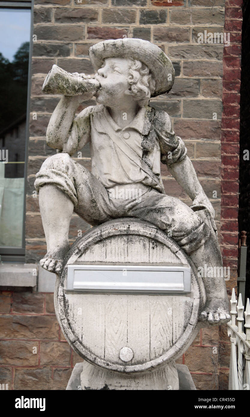 Un divertente piccola scultura di un giovane ragazzo di bere birra su una casa post box in Durbuy, la Vallonia, Belgio. Foto Stock