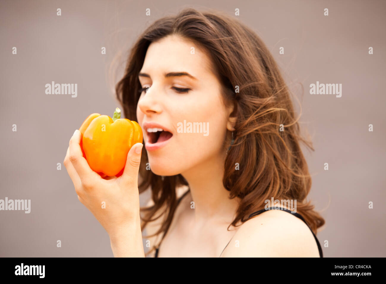 Donna di mangiare un peperone giallo Foto Stock