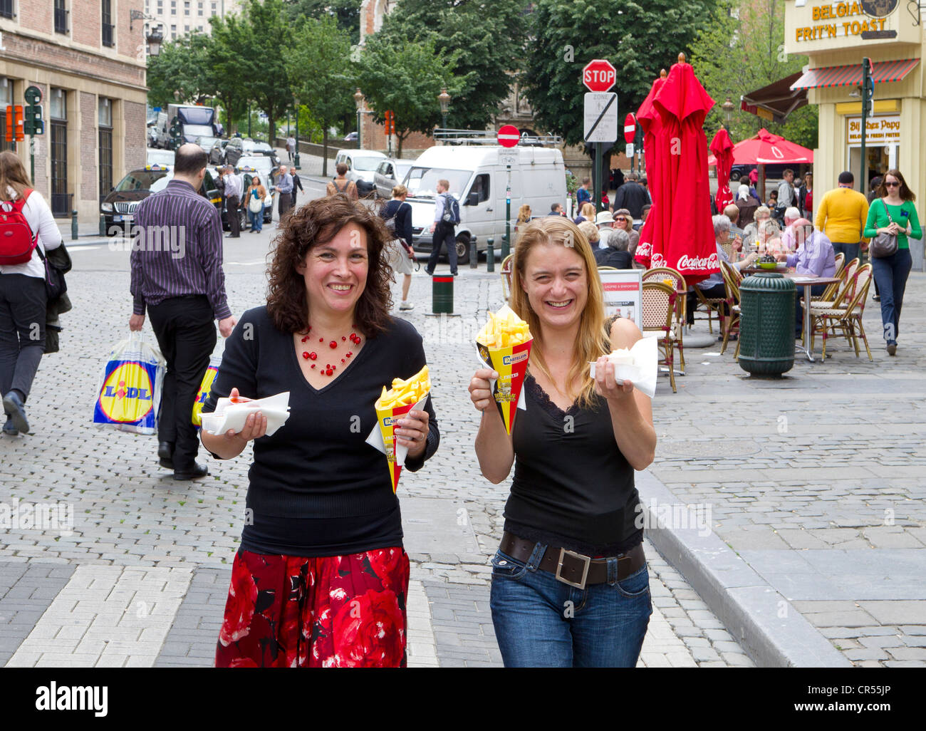 Patatine fritte in Belgio frites bruxelles donna donne ragazza ragazze femmine femmina street snack food sorriso sorridente 2 due Foto Stock