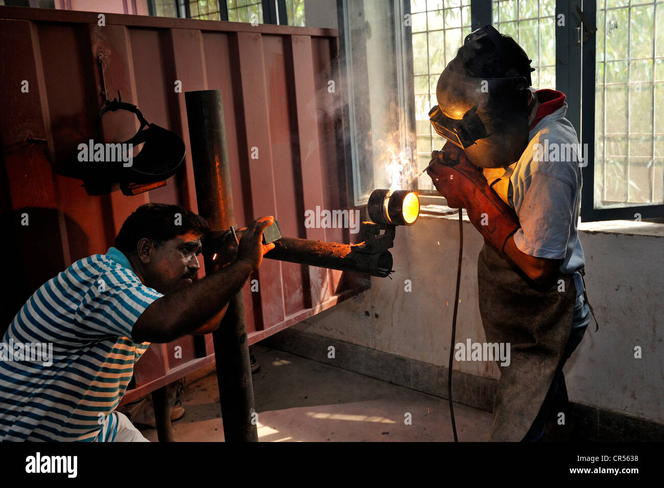 La formazione professionale come un lavoratore metalmeccanico, insegnante, sinistra, controllo della tecnica di saldatura di una formazione studente, Youhanabad, Lahore Foto Stock