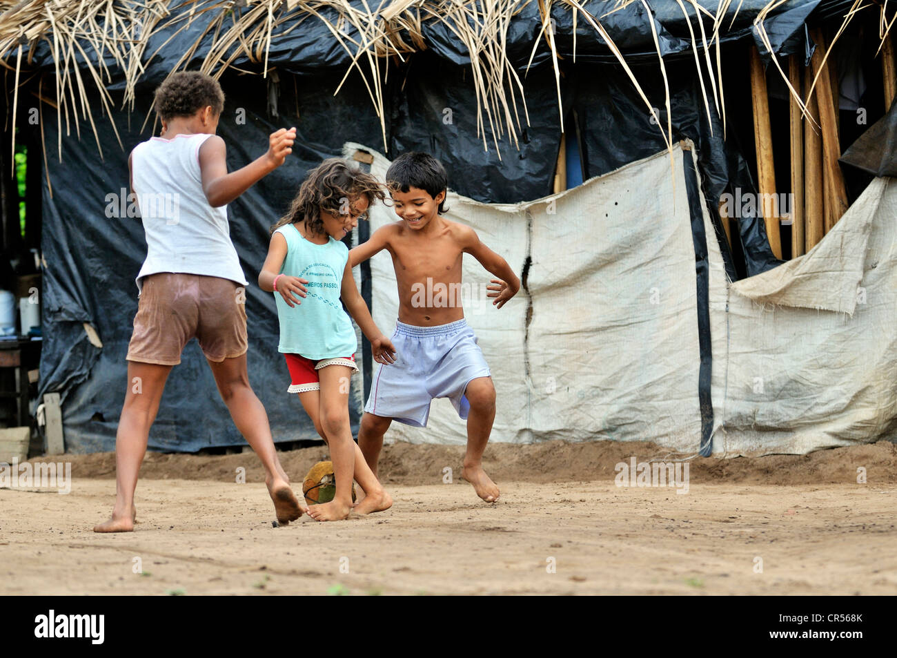 I bambini che giocano a calcio davanti alla loro casa semplice, Acampamento 12 de Otubro landless camp, Movimento dos Trabalhadores Foto Stock
