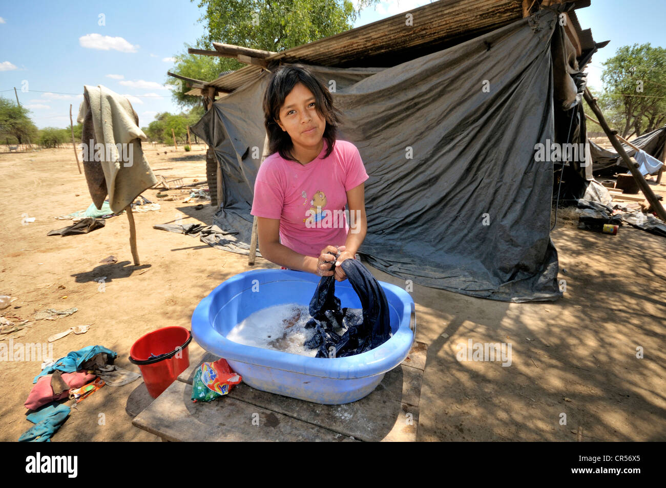 Giovane donna di 18 anni, a fare il bucato in una vasca di plastica, la comunità indigena di Santa Maria, Gran Chaco, Provincia di Salta Foto Stock