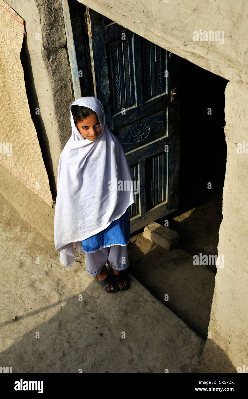 Ragazza alla porta della sua casa fatta di fango, villaggio di Lashari Wala, Punjab, Pakistan, Asia Foto Stock