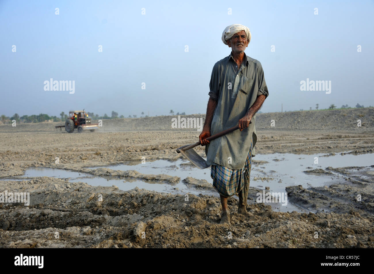 Il vecchio uomo di scavare uno stagno di pesci, Basti Lehar Walla village, Punjab, Pakistan, Asia Foto Stock
