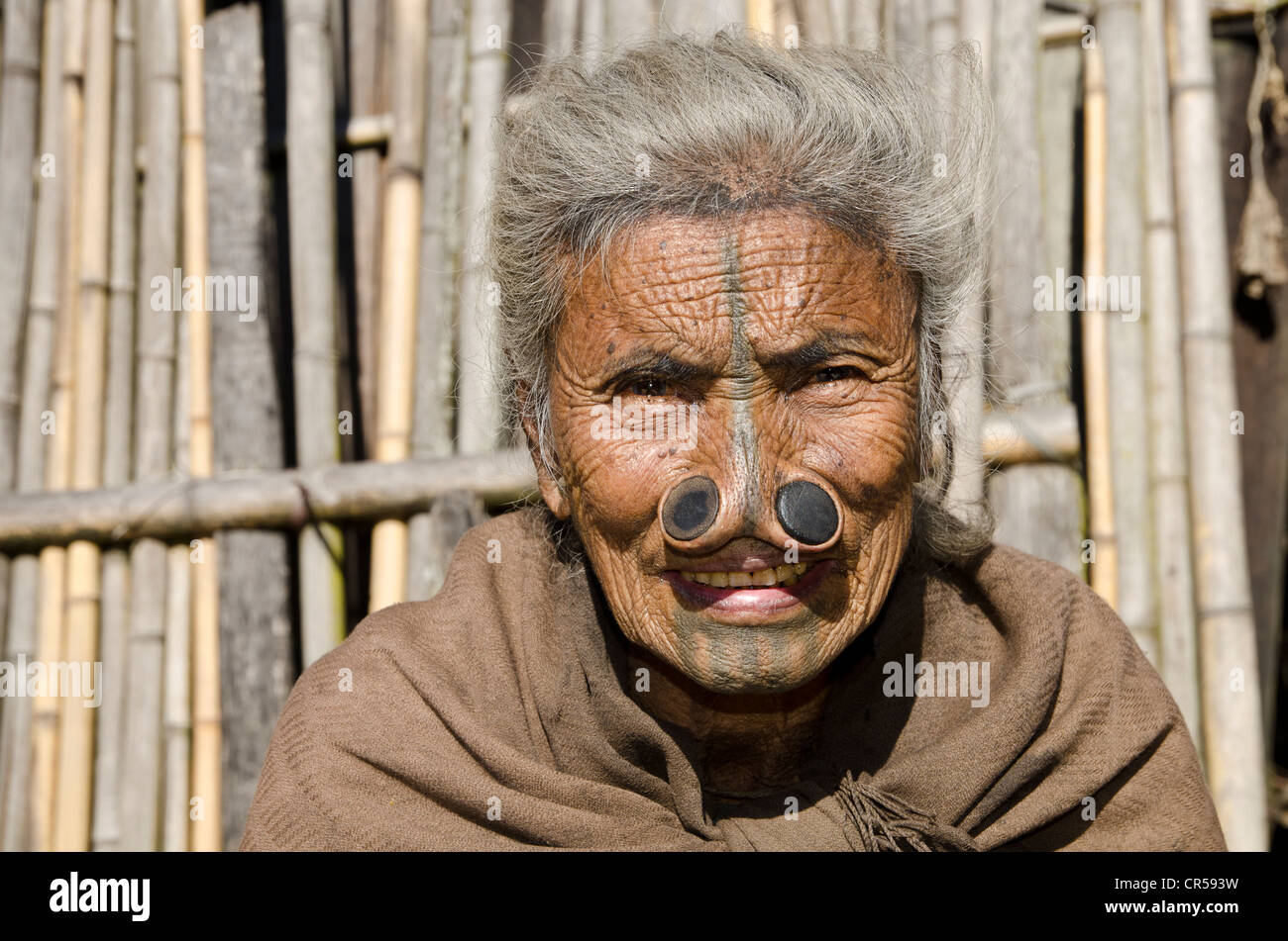 Apatani vecchia donna con la tradizionale noseplugs e tatuaggi, davanti a casa sua, Hong village, Arunachal Pradesh, India Foto Stock