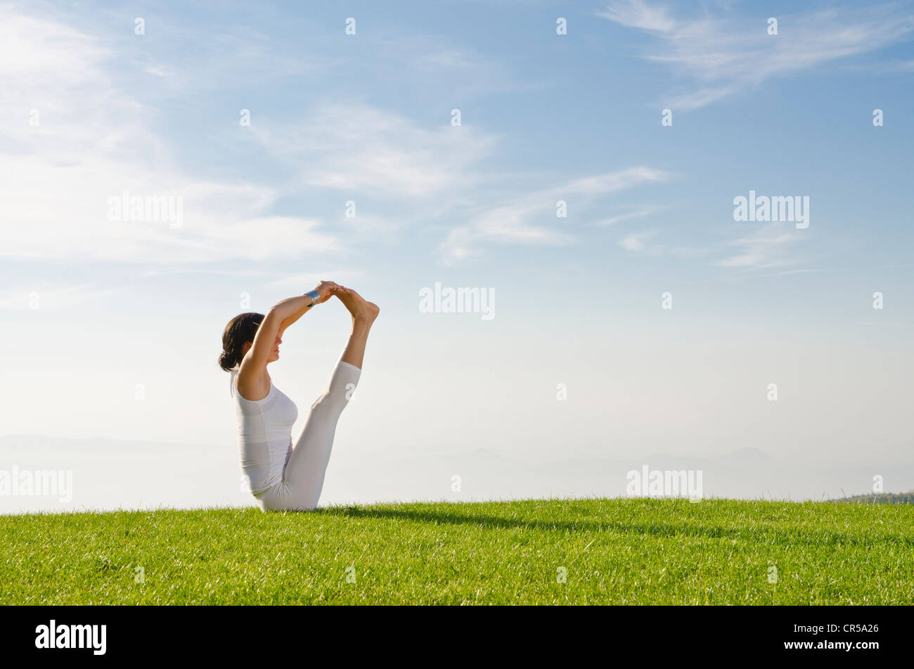 Giovane donna pratica di Hatha yoga all'aperto, che mostra la posa urdhva mukha pashchimottanasana, non supportato Stretching schiena pongono, Foto Stock