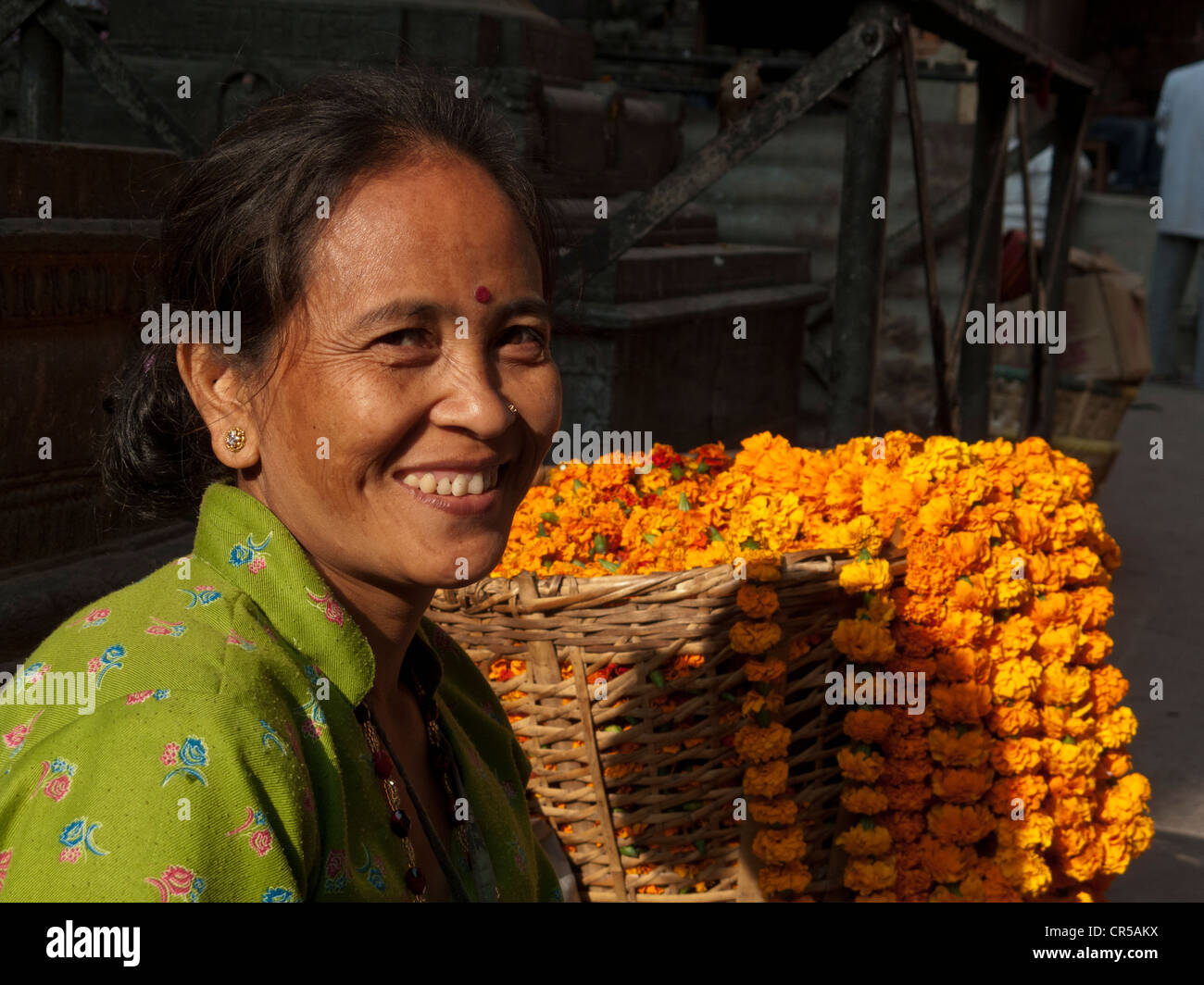 Donna locale che vendono fiori per i rituali religiosi in un mercato, Kathmandu, Nepal, Sud Asia Foto Stock