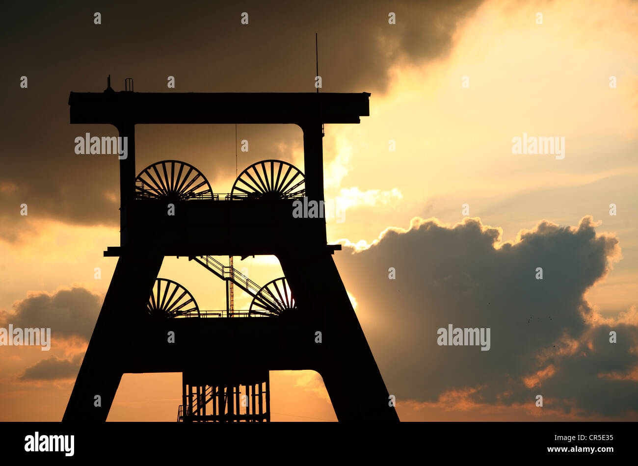 Torre di avvolgimento di un ex miniera di carbone, tramonto, dark sky, nuvole. Simbolo per la fine delle miniere di carbone della Ruhr, Germania. Foto Stock