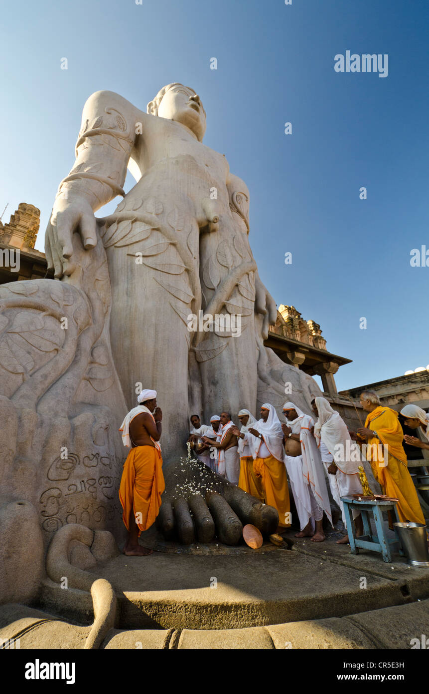 Un gruppo di pellegrini di Jain facendo una speciale pooja davanti alla statua gigantesca per ricevere le benedizioni di Bahubali dal locale Foto Stock
