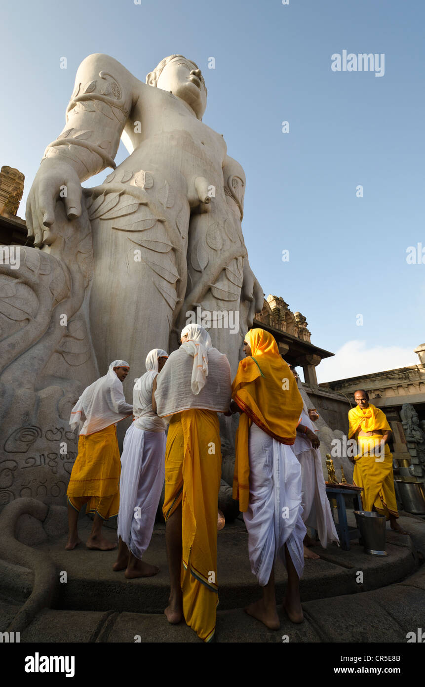 Un gruppo di pellegrini di Jain facendo una speciale pooja per ricevere le benedizioni di Bahubali dai sacerdoti locali, di fronte alla statua di Foto Stock