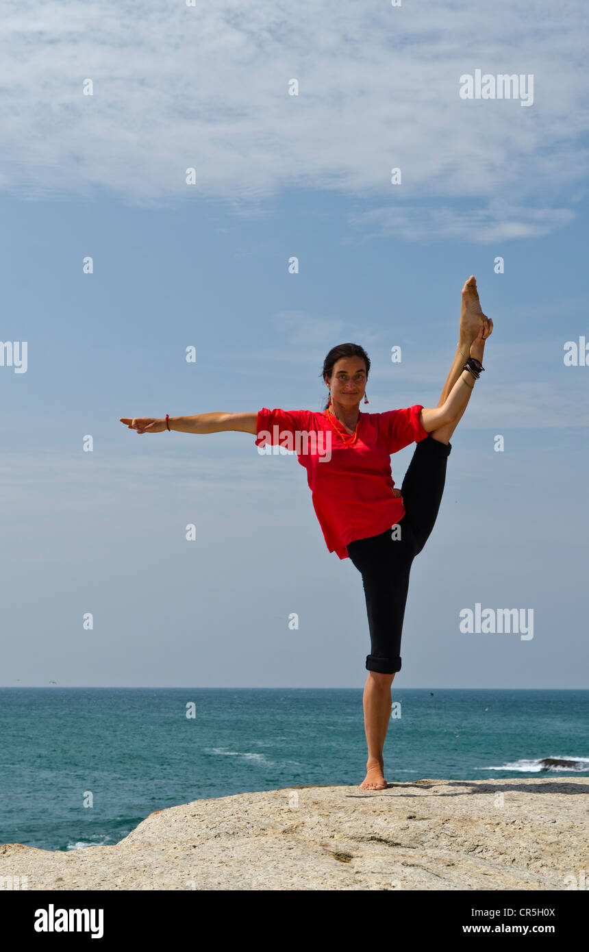 La donna in una posizione di yoga, Anjaneyasana, dal mare in Kanyakumari, Tamil Nadu, India, Asia Foto Stock