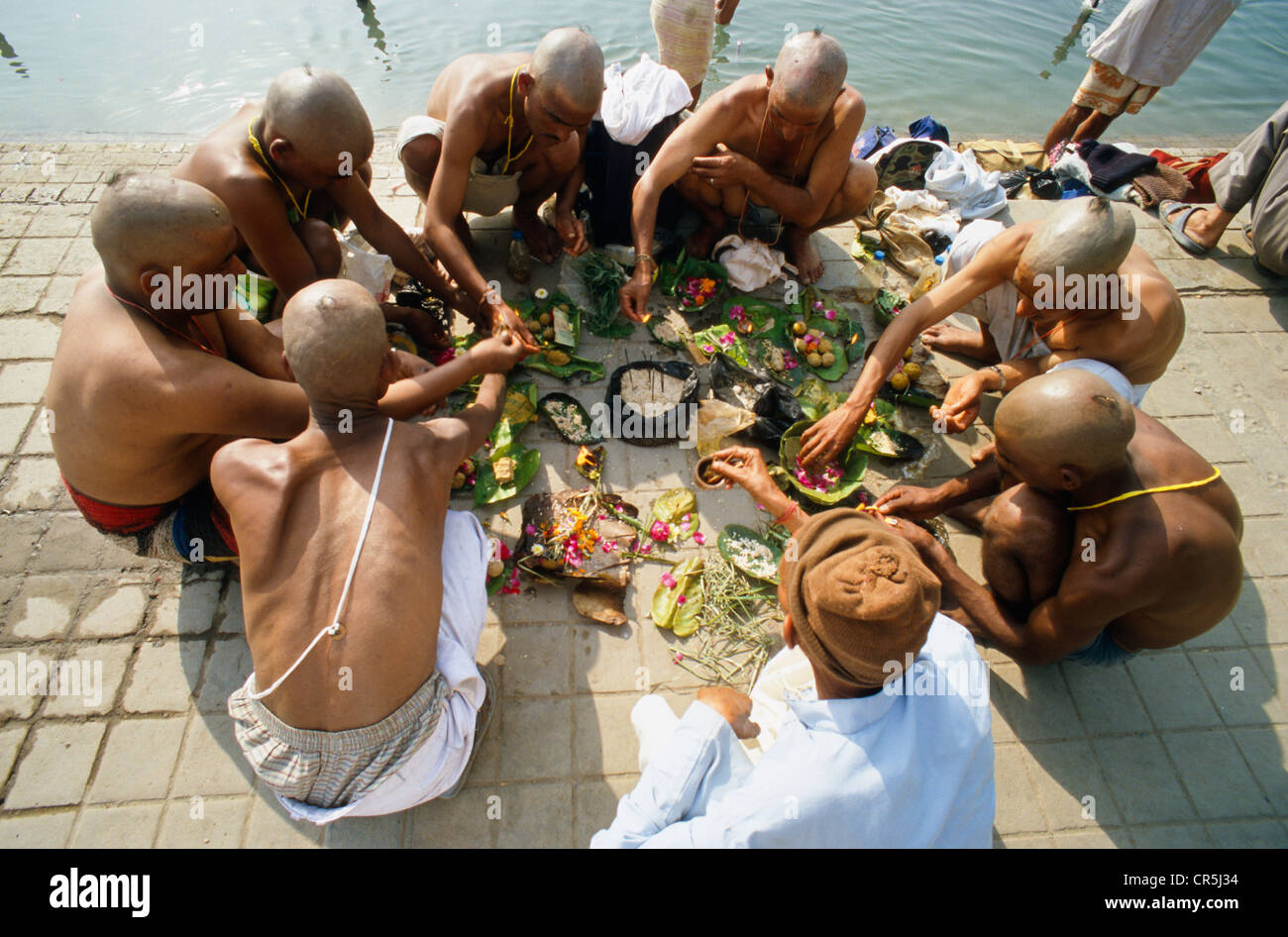 I figli di un uomo morto di pregare per una buona reincarnazione per il loro padre a Har Ki Pauri Ghat in Haridwar, Uttarakhand Foto Stock