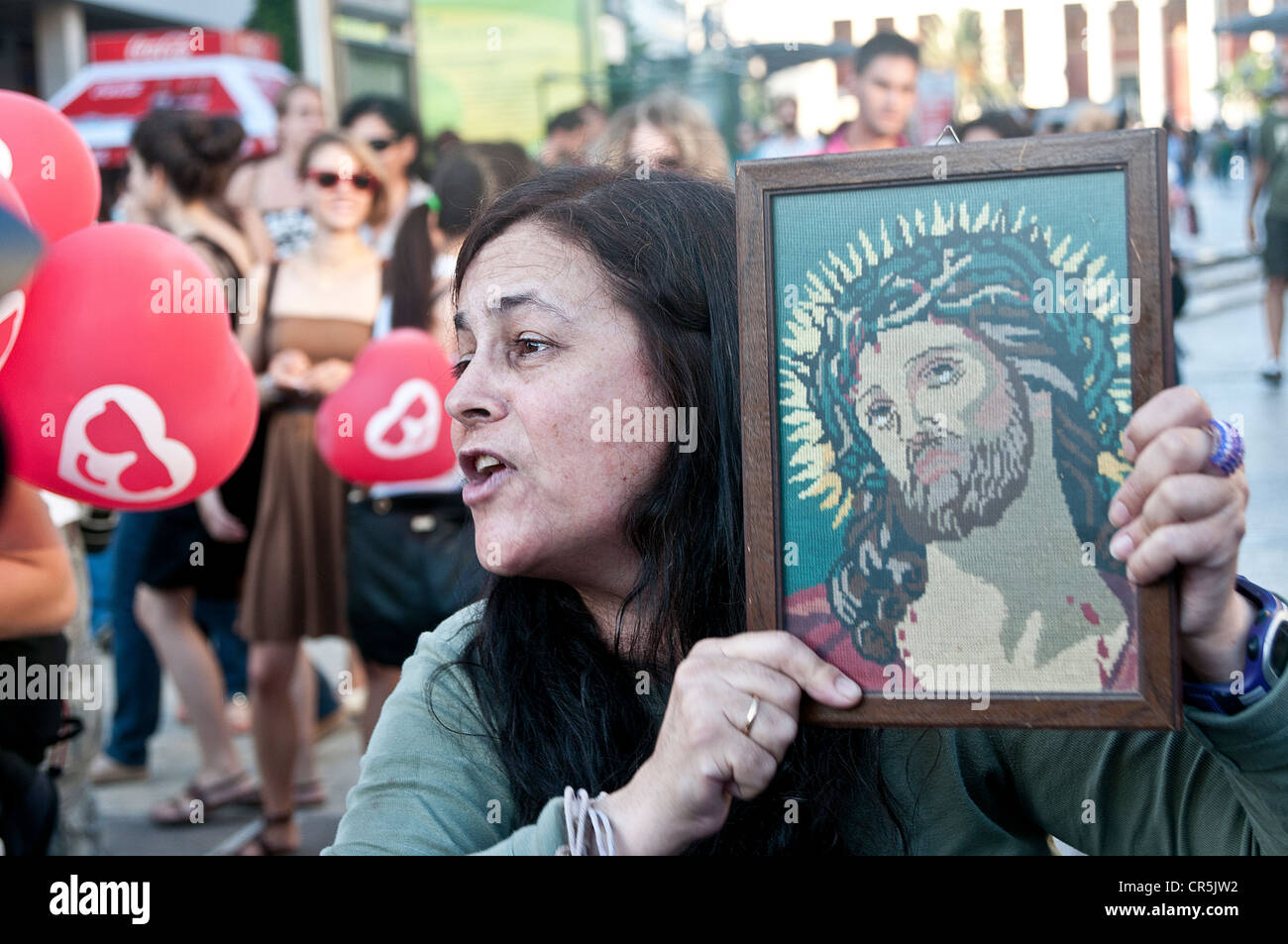 Donna con un icona di Gesù Cristo nelle sue mani predica contro gli omosessuali ad Atene gay parade ' Atene orgoglio' Foto Stock