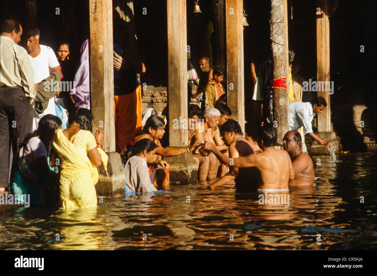 Pellegrini di balneazione in la sorgente del fiume santo Godavari per lavare via i peccati, Trmbak, Maharashtra, India, Asia Foto Stock