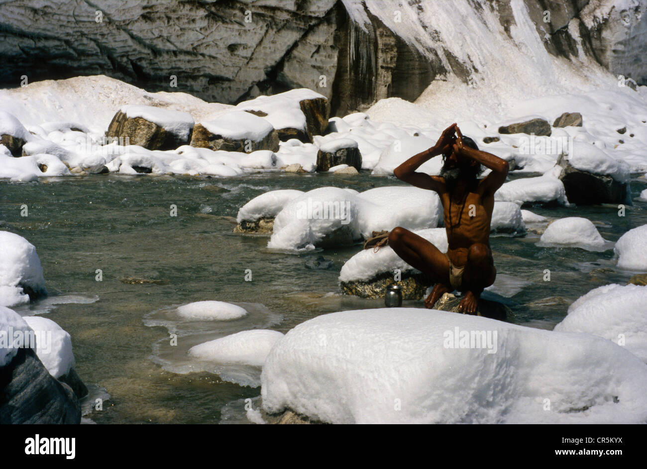 Uomo di prendere un bagno in acqua ghiacciata del fiume sacro Gange che proviene da qui a Gangotri, Uttarakhand Foto Stock
