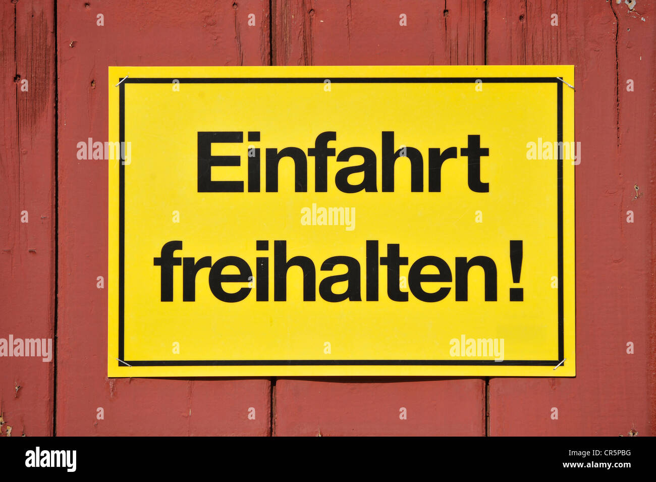 Segno, Einfahrt freihalten! Tedesco per mantenere l'ingresso chiaro, giallo su un rosso cancello in legno, Germania, Europa Foto Stock