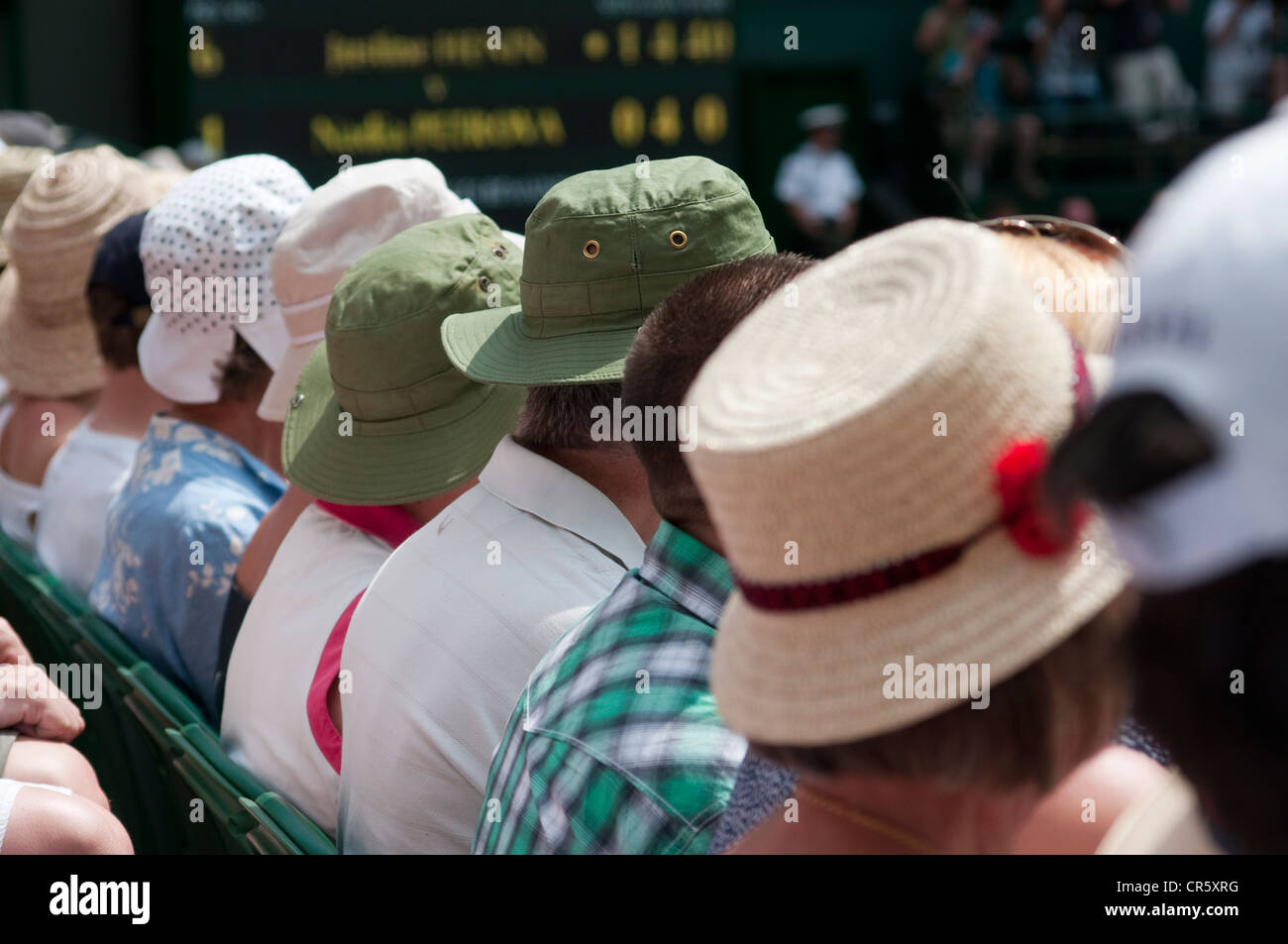 Una fila di persone che indossano cappelli sul Centre Court, Wimbledon. Foto Stock