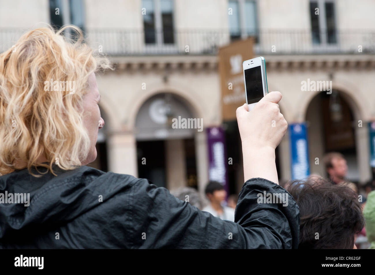 Parigi, Francia - Una donna prendendo foto con il telefono cellulare Iphone Foto Stock