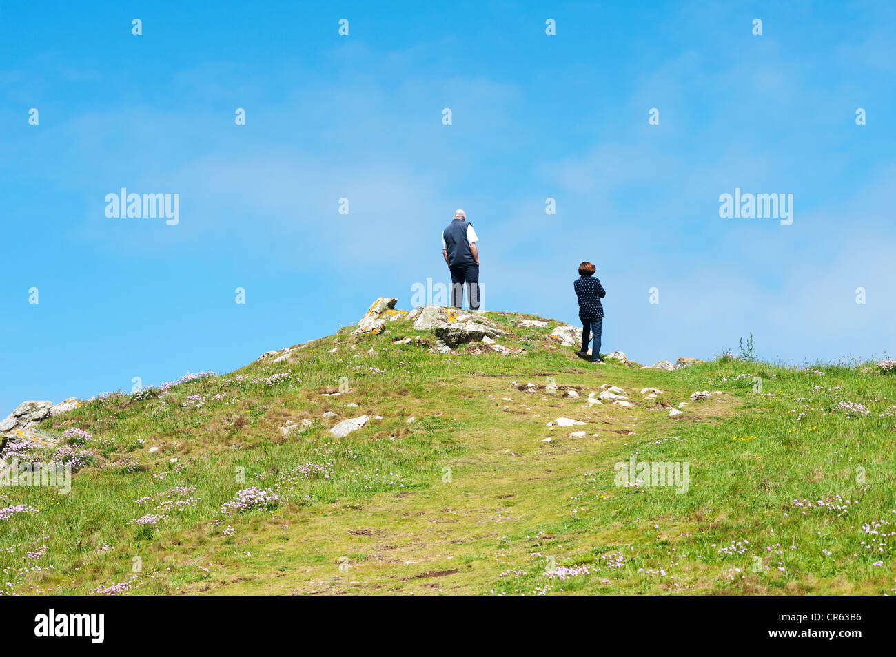 Cornovaglia, England Regno Unito - un uomo e una donna in piedi sulla cima di una collina con vista al mare Foto Stock