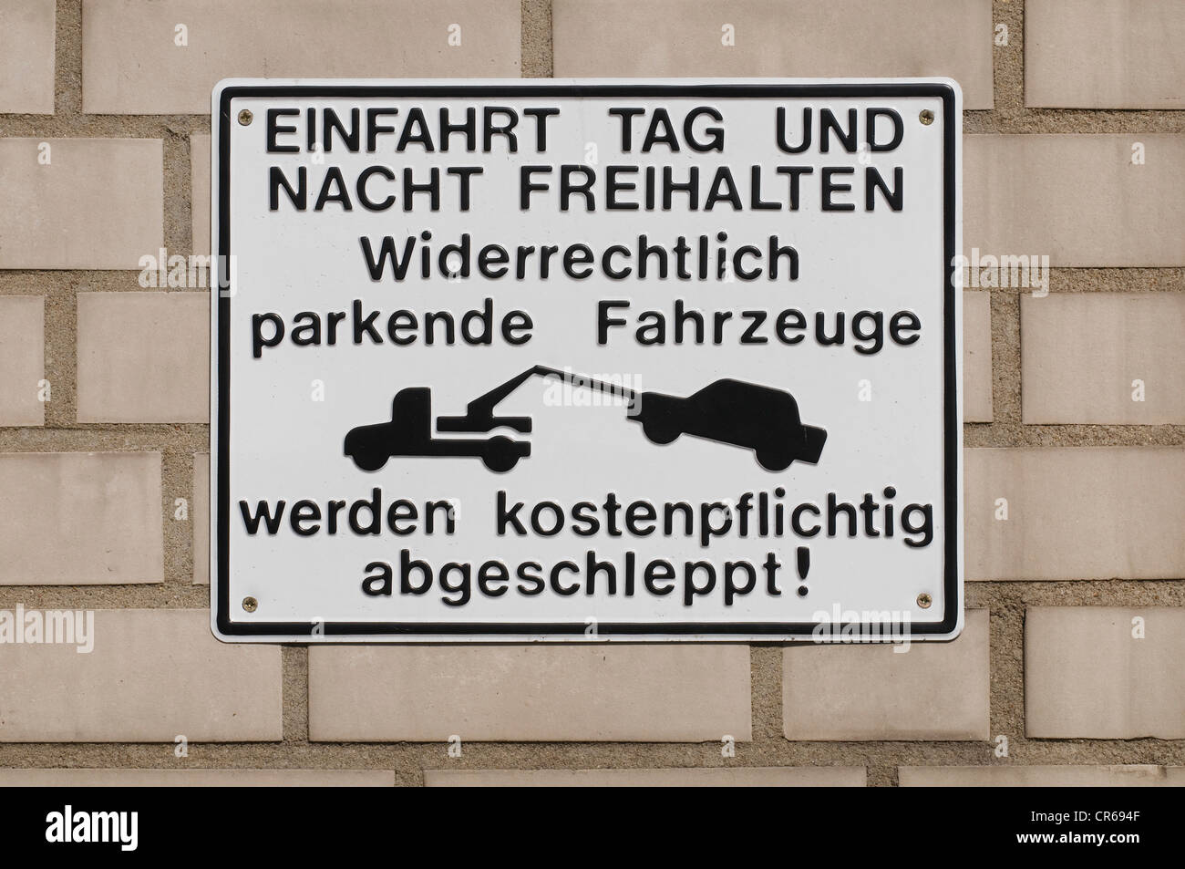 Cantare sulla parete con carroattrezzi pittogramma, 'Einfahrt Tag und Nacht freihalten, widerrechtlich geparkte Fahrzeuge werden Foto Stock