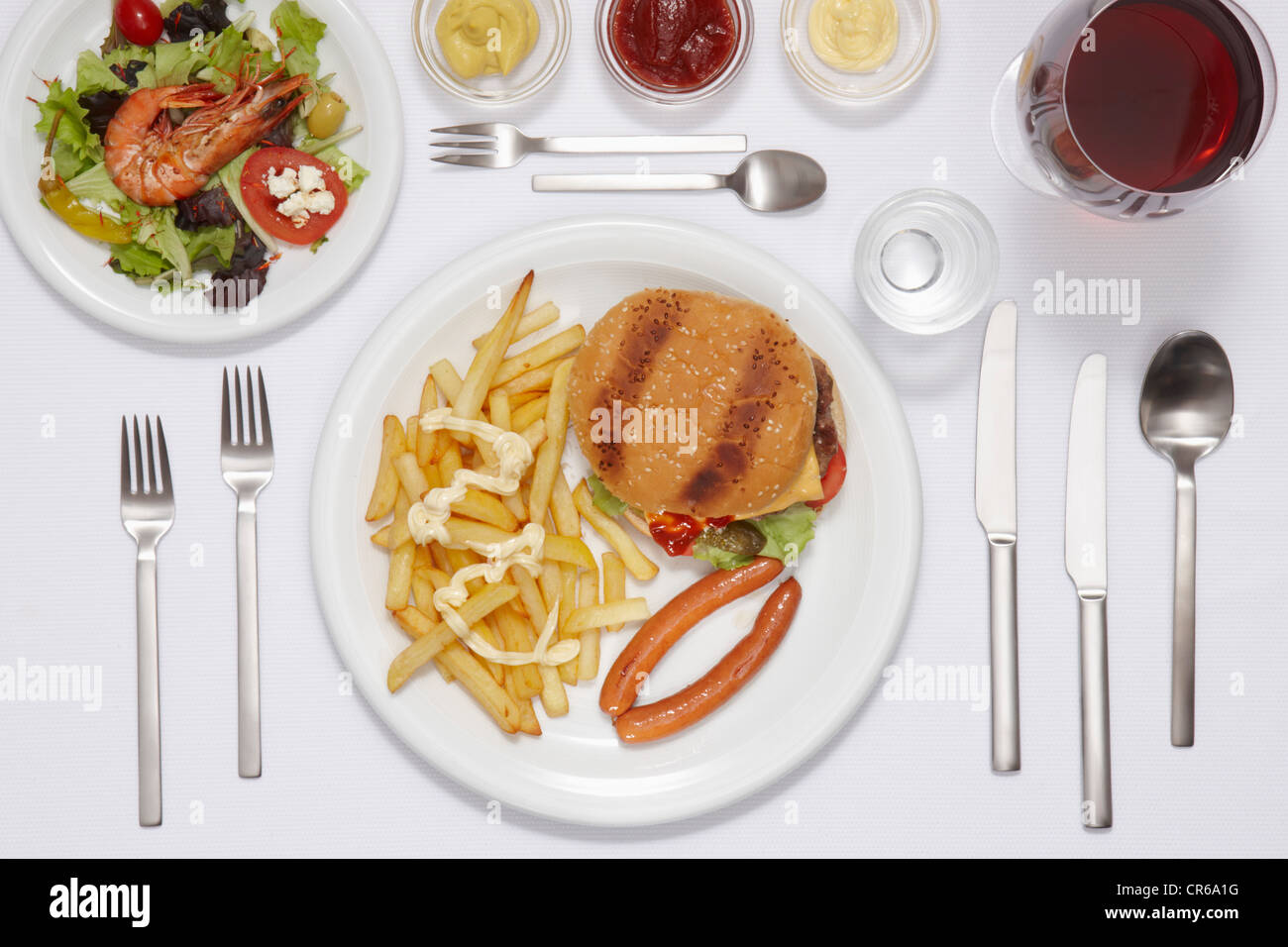 Hamburger, patatine fritte, insalate e piatti di pesce nella piastra Foto Stock