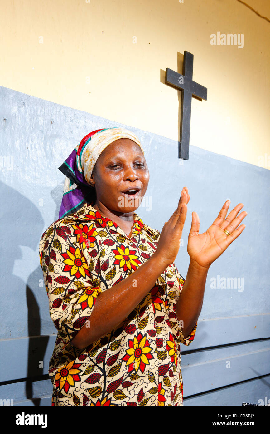 Donna durante la preghiera del mattino in servizio la tubercolosi e lebbra insediamento, Manyemen, Camerun, Africa Foto Stock
