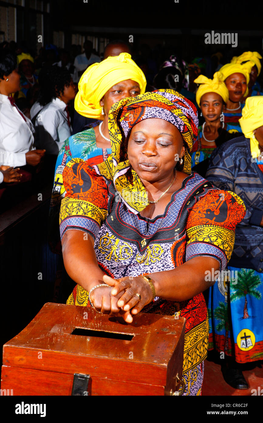 La donna la donazione di denaro a una domenica servizio di chiesa, di Bamenda, Camerun, Africa Foto Stock