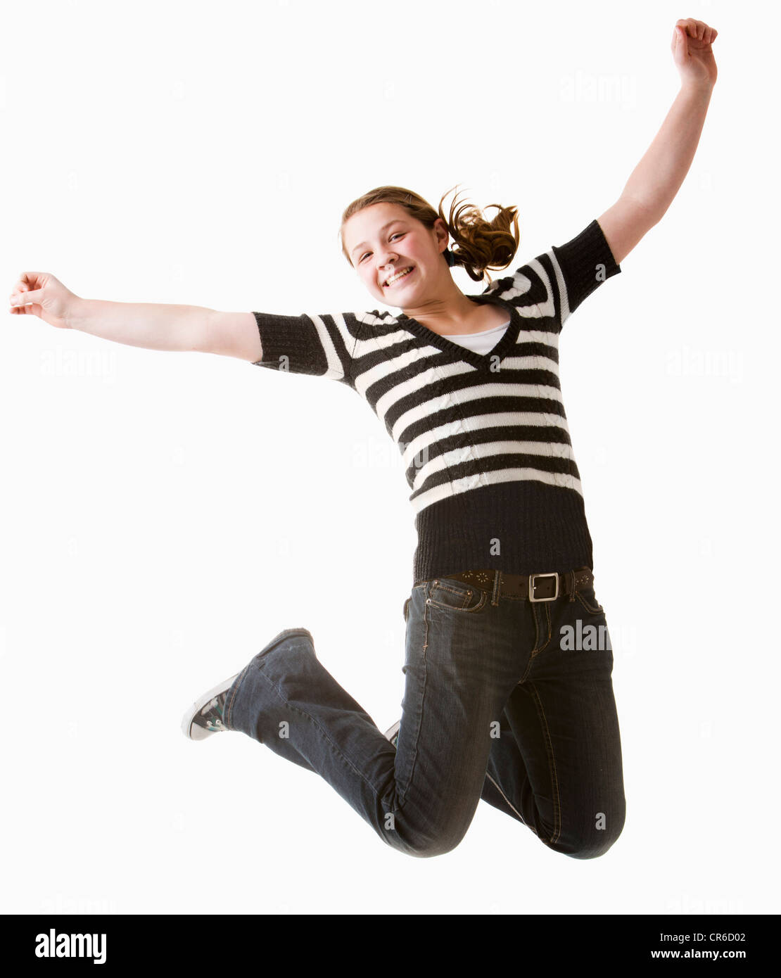 Studio shot della ragazza (12-13) jumping con le braccia sollevate Foto Stock