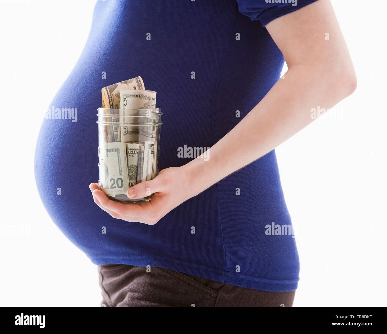 Studio shot della sezione centrale della donna incinta foratura jar con denaro Foto Stock