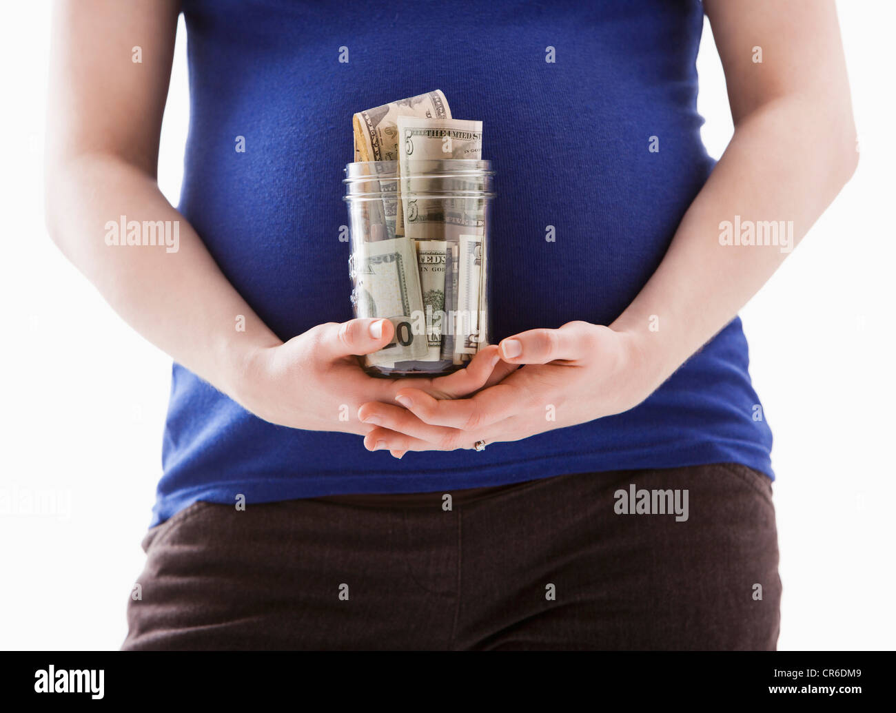 Studio shot della sezione centrale della donna incinta foratura jar con denaro Foto Stock