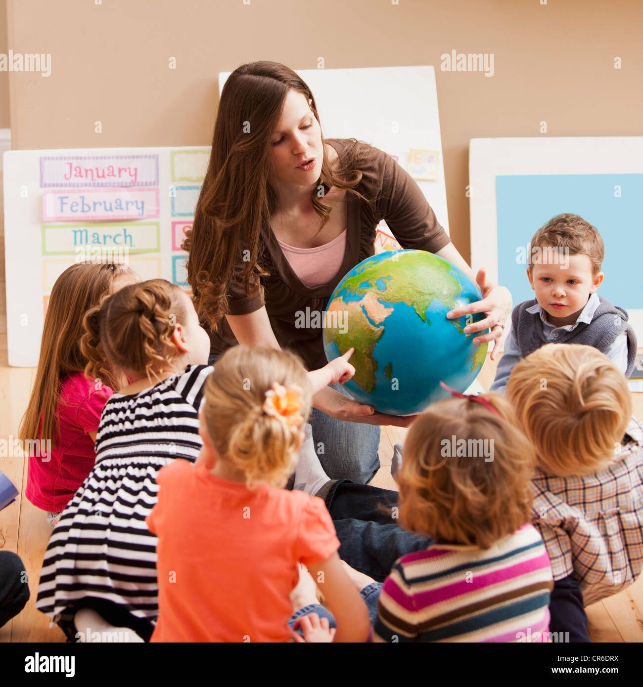 Insegnante con bambini (2-3, 4-5) apprendimento geografia Foto Stock