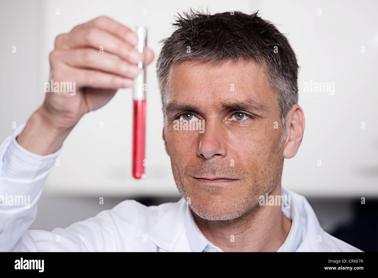In Germania, in Baviera, Monaco di Baviera, scienziato di contenimento di liquido rosso in provetta per la ricerca medica in laboratorio Foto Stock
