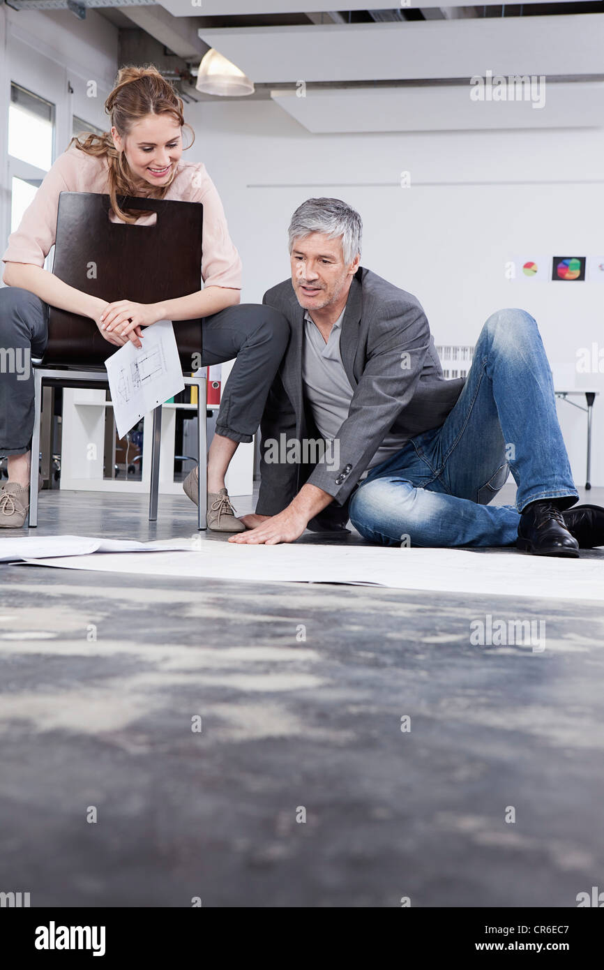 In Germania, in Baviera, Monaco di Baviera, uomini spiegando piano per donne in ufficio Foto Stock
