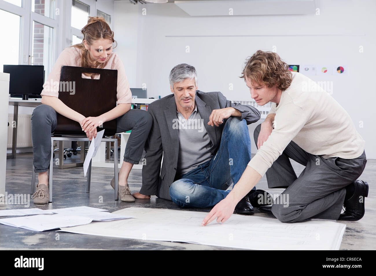 In Germania, in Baviera, Monaco di Baviera, uomo piano di spiegare ai colleghi in ufficio Foto Stock