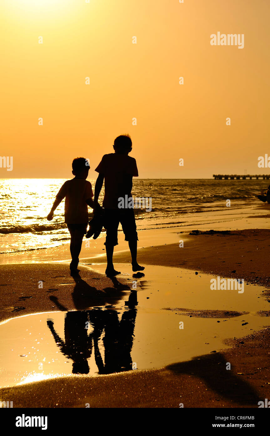 Due ragazzi di camminare sulla spiaggia, atmosfera serale, Lido di Ostia, Roma, Regione Lazio, Italia, Europa Foto Stock