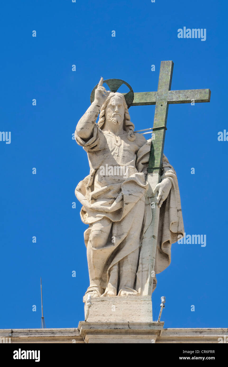 Statua di Gesù tenendo una croce sopra i colonnati, Basilica di San Pietro, Basilica di San Pietro e la Città del Vaticano, Roma Foto Stock