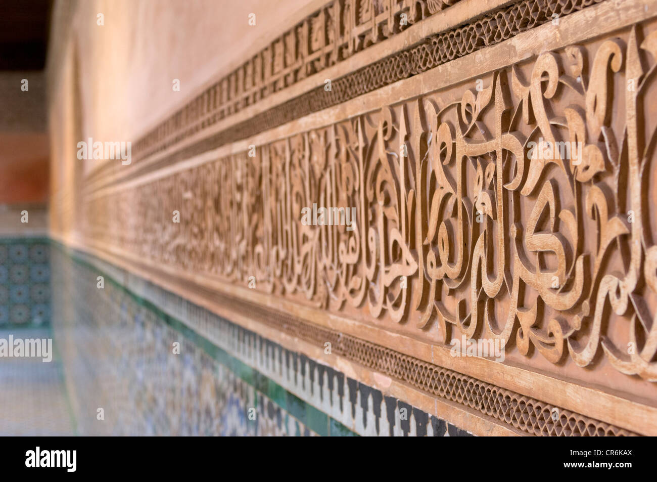 Inscizioni di versetti coranici e motivi geometrici intagliati nel gesso, che decorano il cortile interno della Madrasa Ben Youssef, Marrakech, Marocco Foto Stock