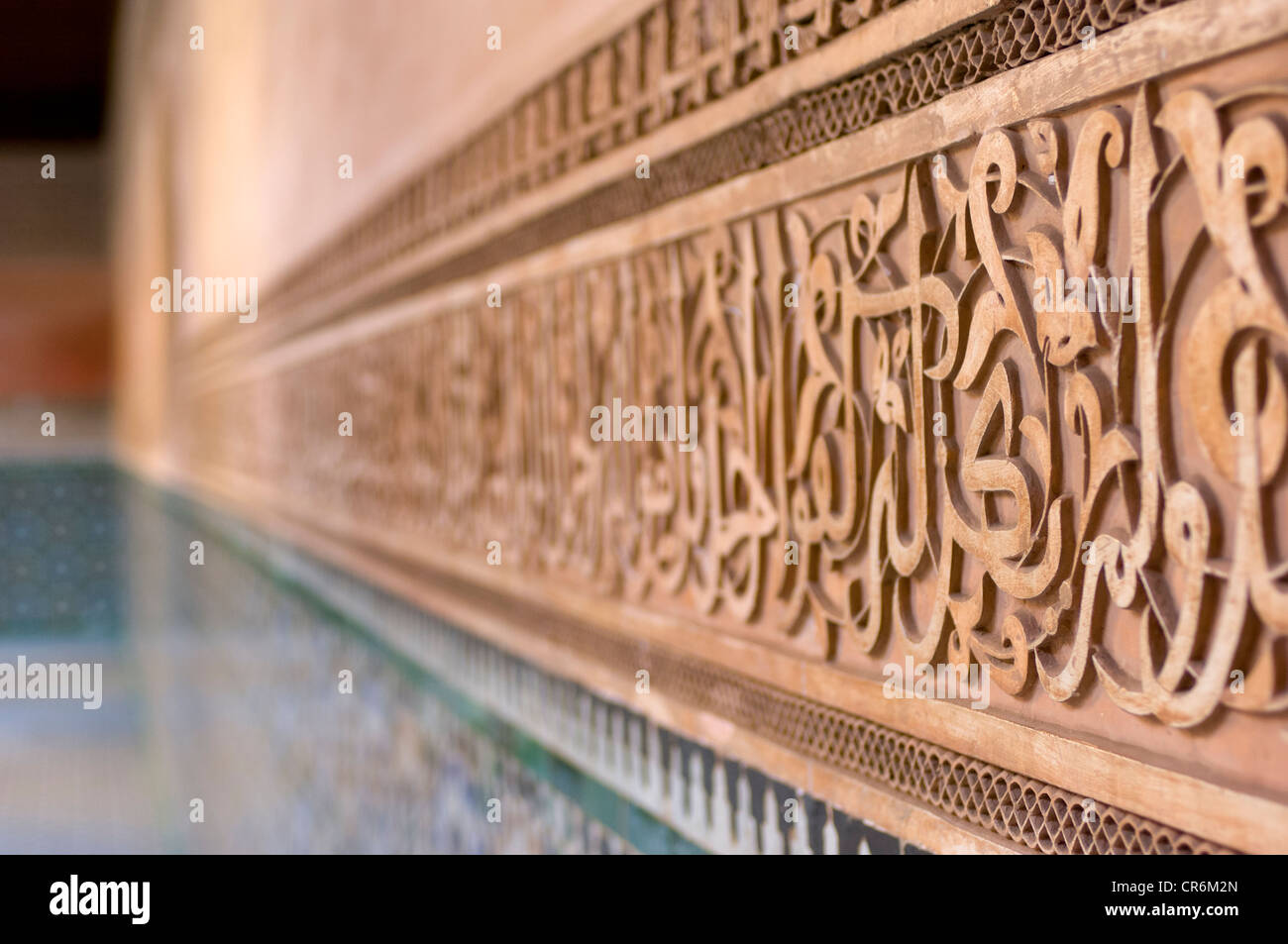 Inscizioni di versetti coranici e motivi geometrici intagliati nel gesso, che decorano il cortile interno della Madrasa Ben Youssef, Marrakech, Marocco Foto Stock