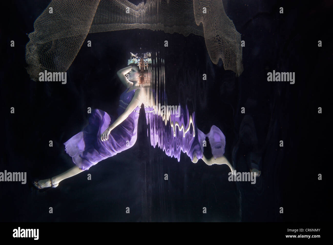 La donna caucasica nel vestire nuotare sotto l'acqua Foto Stock